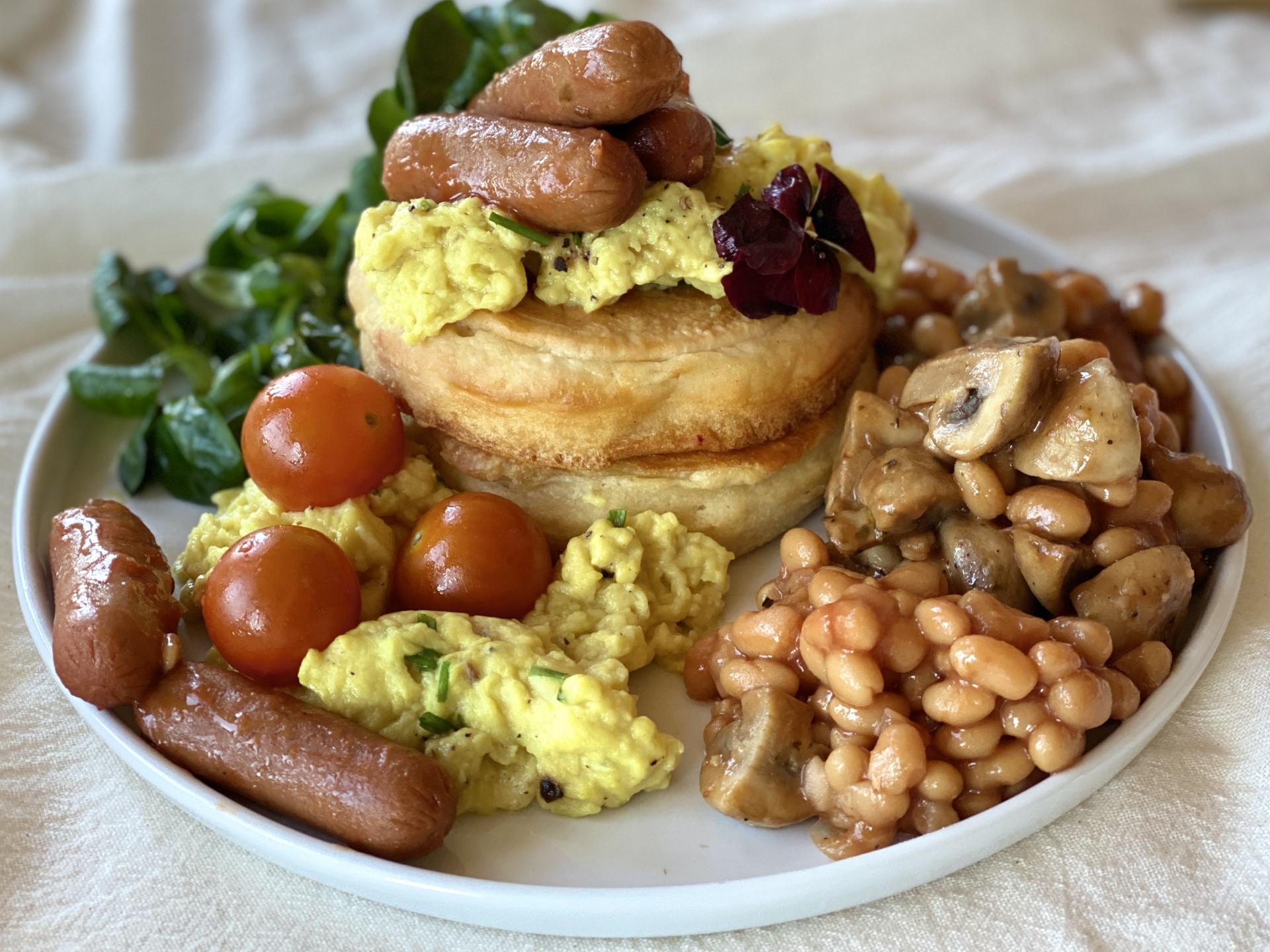 Vegan English Breakfast Stack met vegan omelet, worstjes en spek, witte bonen en champignons